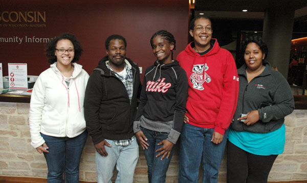 Anthony and four classmates posing in front of the UW–Madison Community Information desk.
