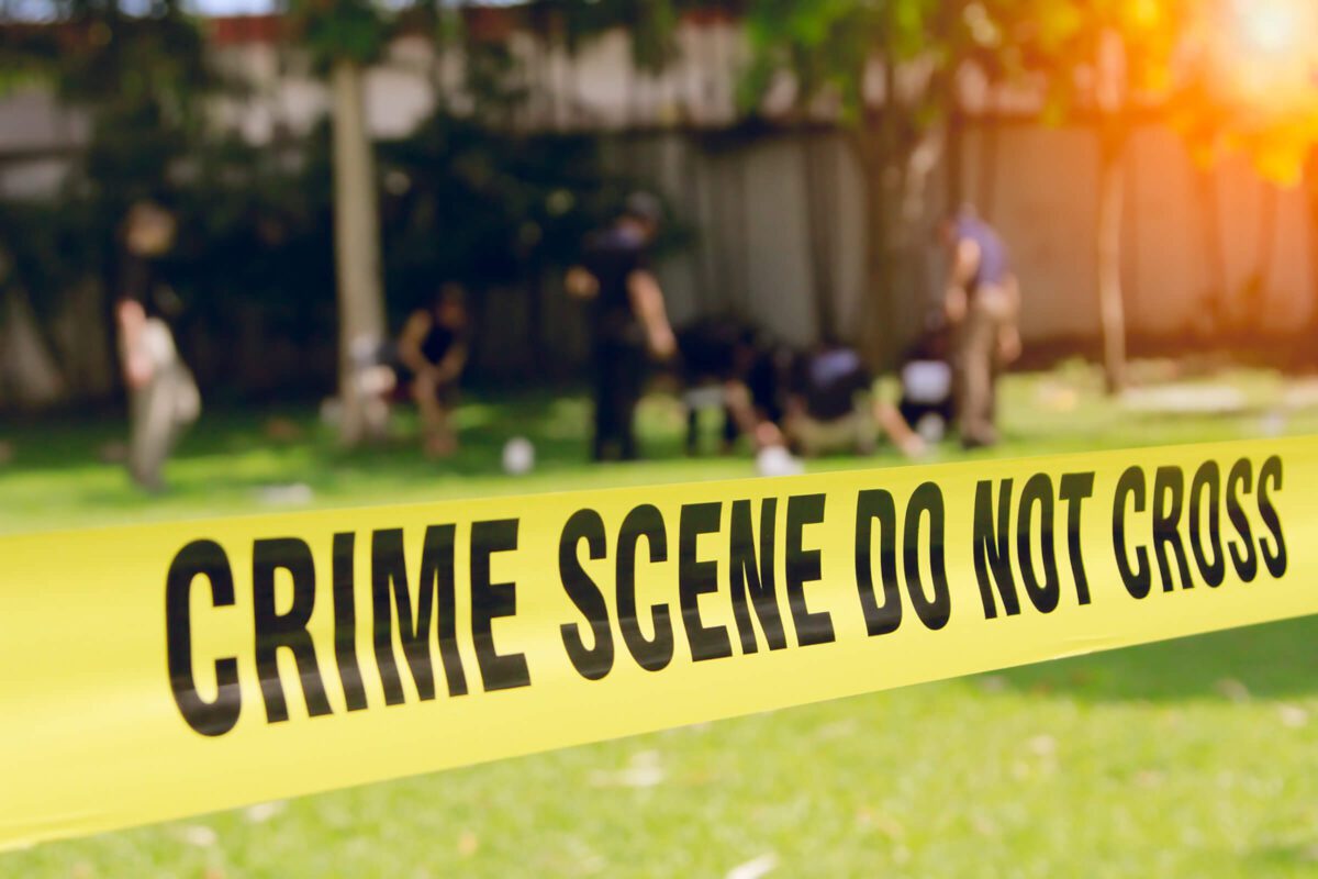 crime scene tape and blurred law enforcement team background