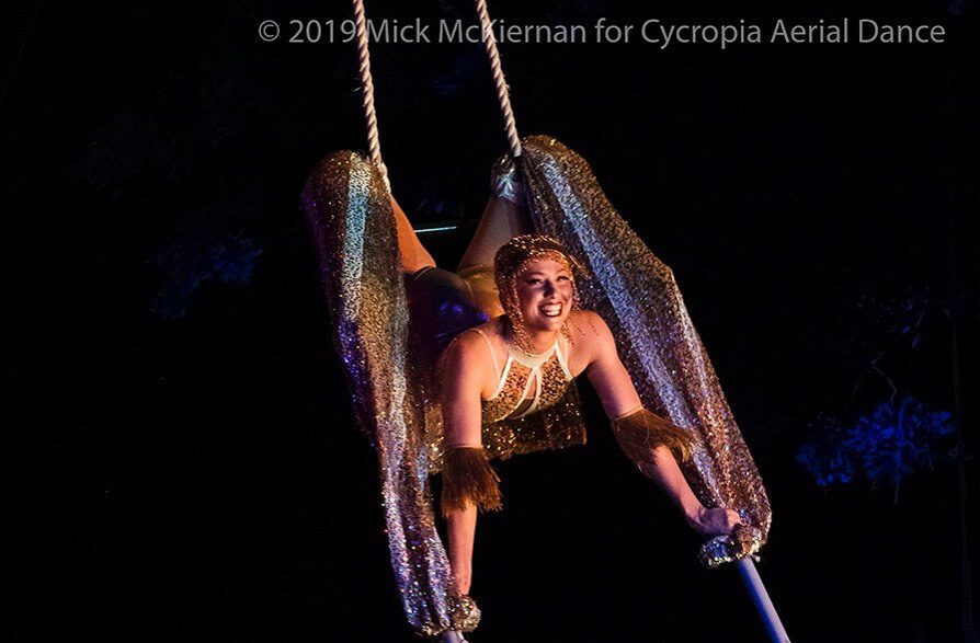 woman flying through the air on silks at a show in the Madison Circus Space