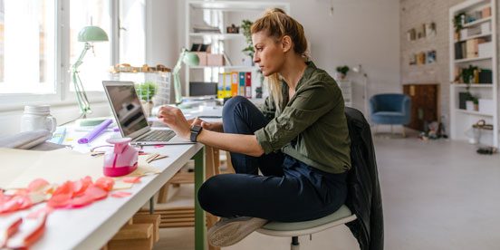 Woman using laptop in an artsy office setting