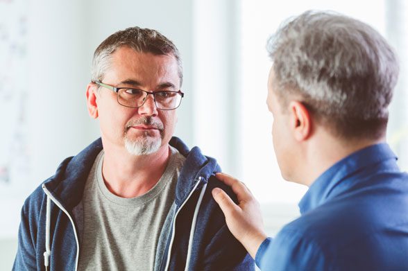 A sympathetic psychotherapist talking with depressed man
