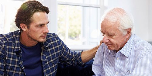 Younger man comforts elderly man