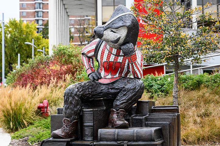 Bucky statue at alumni park surrounded by plants and flowers