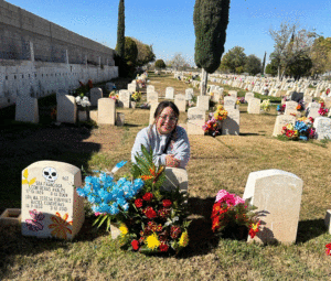 Lily Loera kneeling at her grandfather's gravesite.