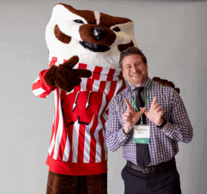 Stephan Blanz smiling next to Bucky Badger