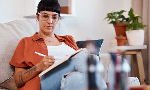 A student works on classwork from her couch.